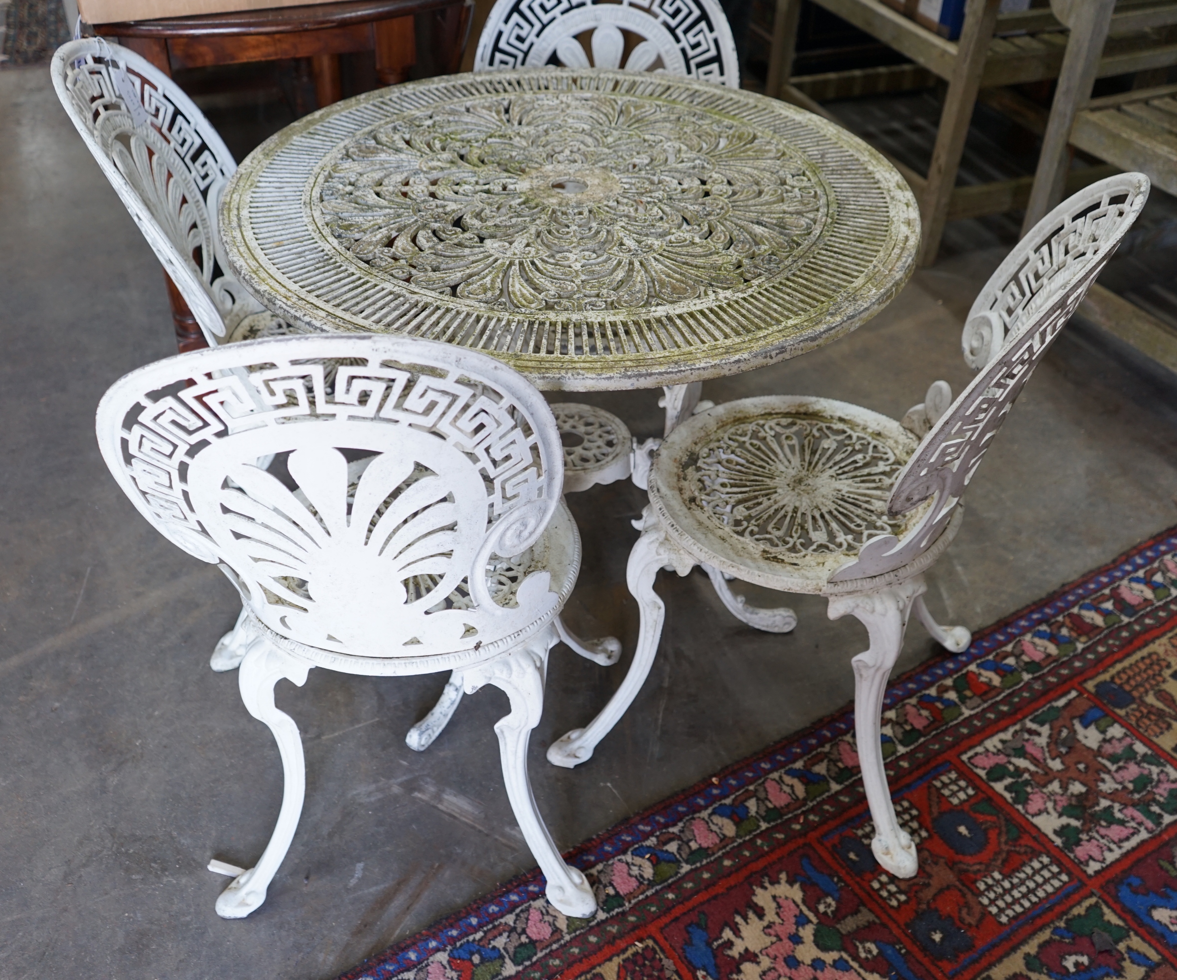 A Victorian style painted aluminium garden table and four chairs, table diameter 80cm height 69cm